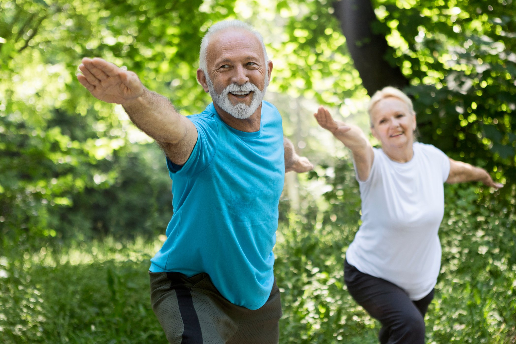 Older couple stretching ,doing yoga in park